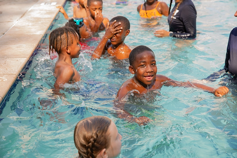 a group of kids playing in a swimming pool